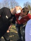 Jugendlicher gibt Wasser mit einem Becher im Mund weiter an zweite Person