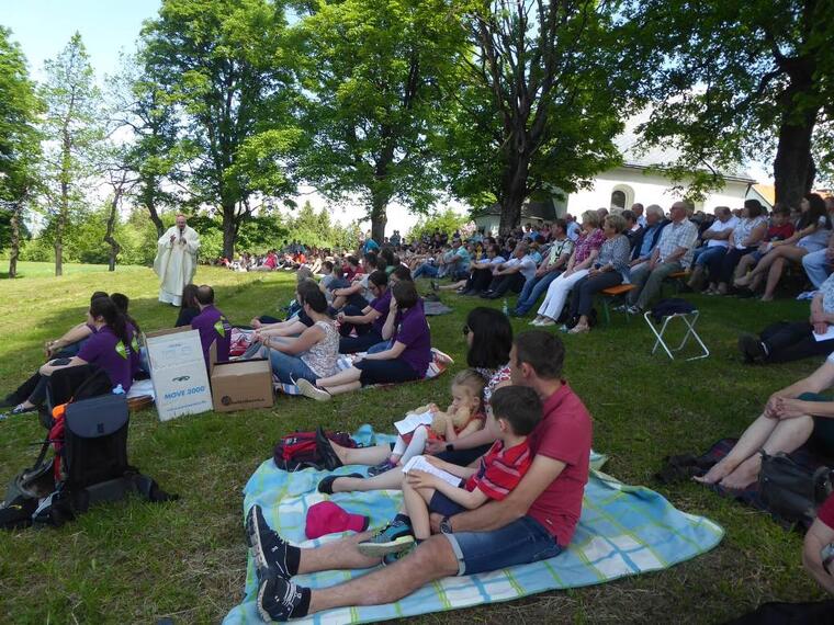 Gottesdienstteilnehmer sitzen auf der Wiese