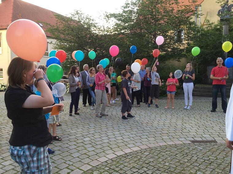 Besucher stehen versammelt auf dem Kirchplatz 