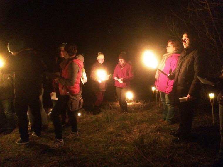 Teilnehmer mit Fackeln im Wald