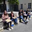 5 Mädchen auf der Mauer beim Pizzaessen